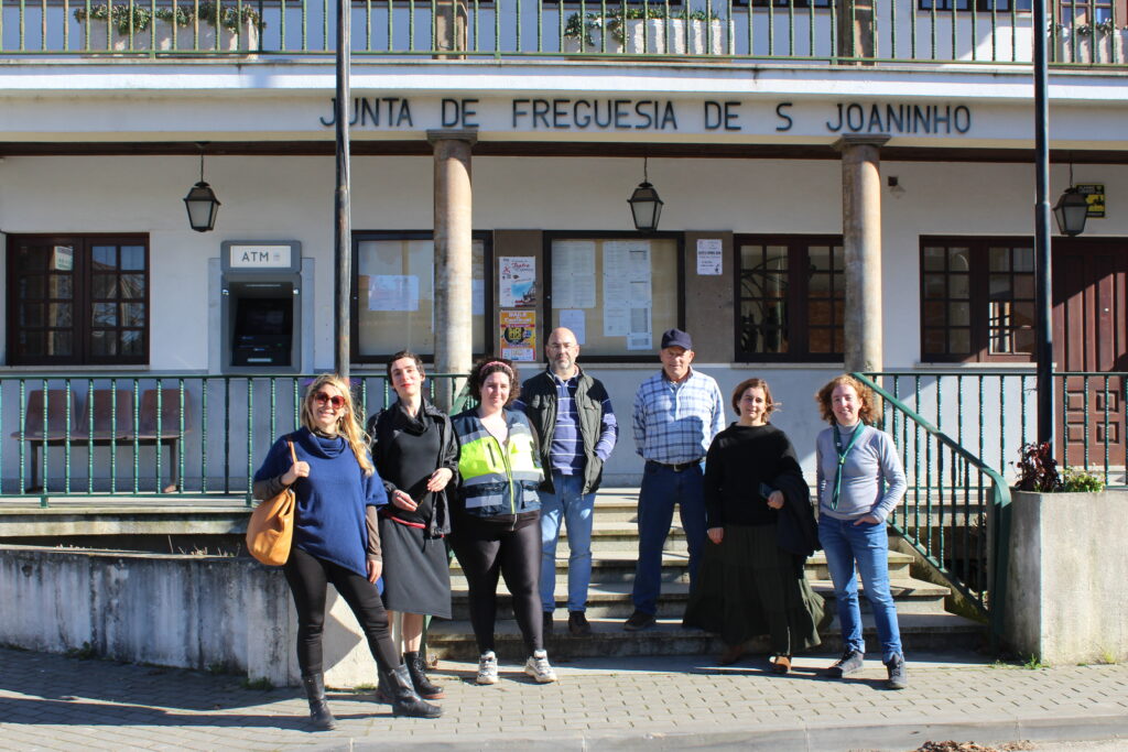A group of people in front of a building in a small village in Portugal